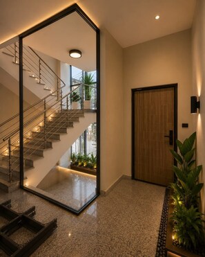 A modern interior with a glass-enclosed staircase, a wooden door, and a potted plant. - Spacious 3BR Serviced Apartment Near Bole Airport (Addis Ababa)