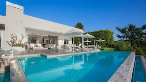 A modern house with a swimming pool, outdoor seating, and umbrellas. - Lemmer Grange (Los Angeles)