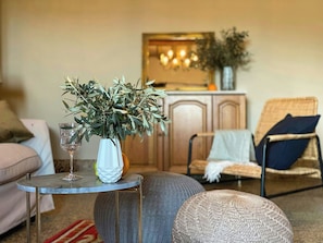 A living room with a round table, a sofa, a chair, and a decorative plant in a vase. - Medieval house with jacuzzi in Val di Cecina (Castelnuovo di Val di Cecina)