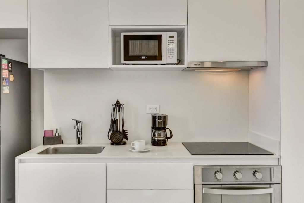 A kitchen with a microwave, coffee maker, and stove.