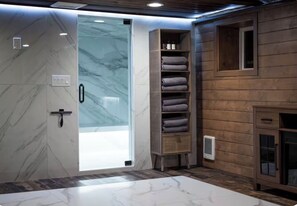A bathroom with a marble floor, a wooden wall, and a shelf with towels. - Mountain View Estate Entire Cabin in Snoqualmie Pass, 16+ Sauna SteamRoom Hottub (Snoqualmie Pass)