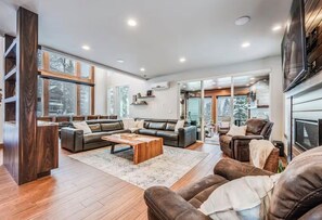 A spacious living room with a large window, a fireplace, and a cozy seating area. - Mountain View Estate Entire Cabin in Snoqualmie Pass, 16+ Sauna SteamRoom Hottub (Snoqualmie Pass)