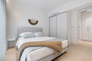 Ein modernes Schlafzimmer mit einem Bett, einem Wanddekor und einem Kleiderschrank.
