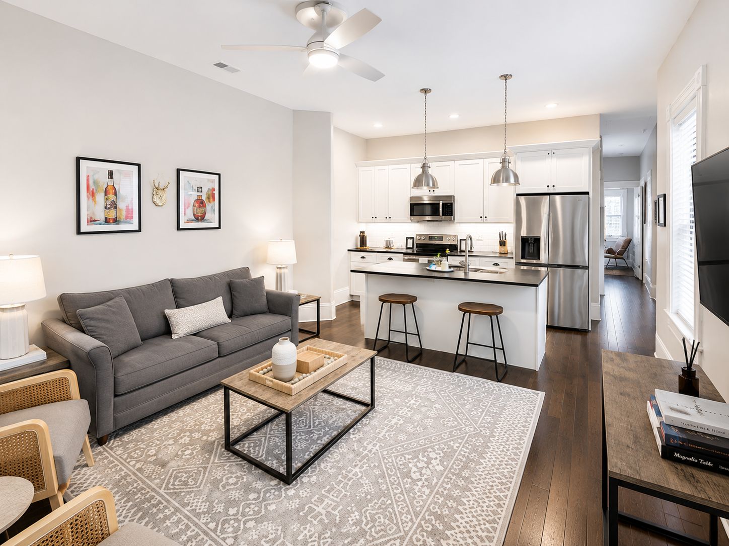 A modern living room with a grey sofa, a coffee table, and a patterned rug.