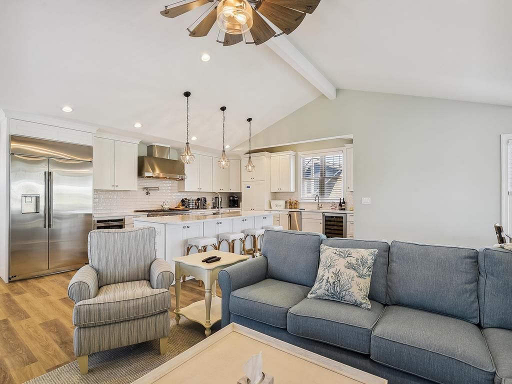 A modern kitchen with a central island, stainless steel appliances, and pendant lighting.