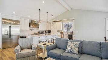 A modern kitchen with a central island, stainless steel appliances, and pendant lighting.