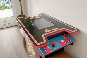 A pinball machine with a colorful design and a joystick. - Taneycomo Wake & Lake | NEW • Private Pool (Branson)