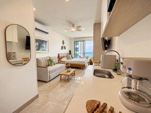 A modern hotel room with a bed, sofa, and a kitchenette. - SAVIAsamaria. Loft con balcón de vista al mar en lujoso resort (Santa Marta)
