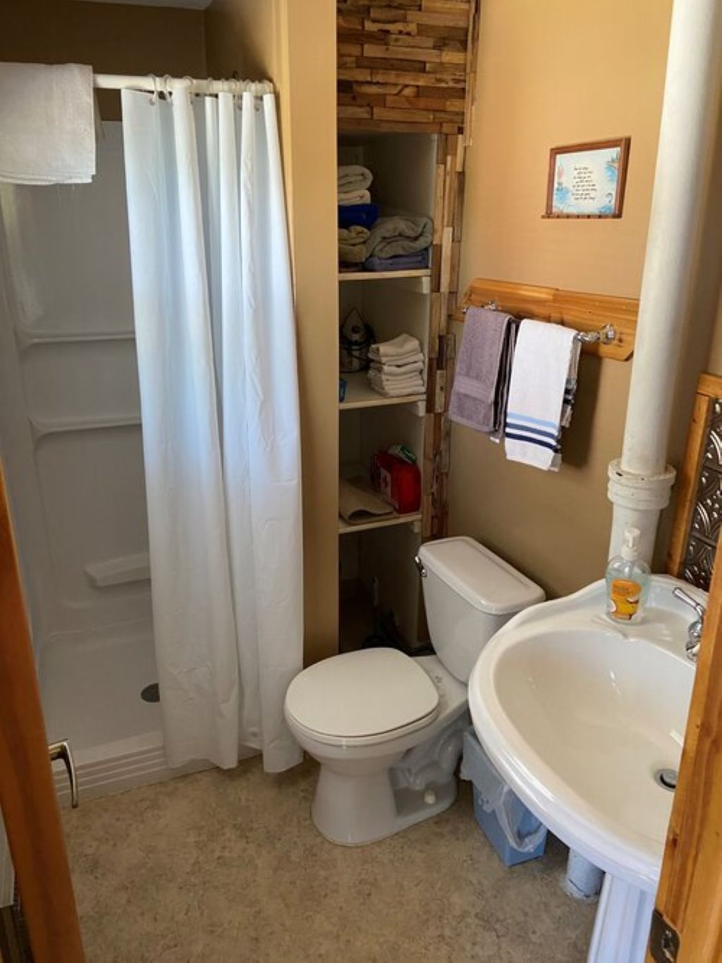 Une salle de bain comprenant des toilettes, un lavabo et un espace douche.