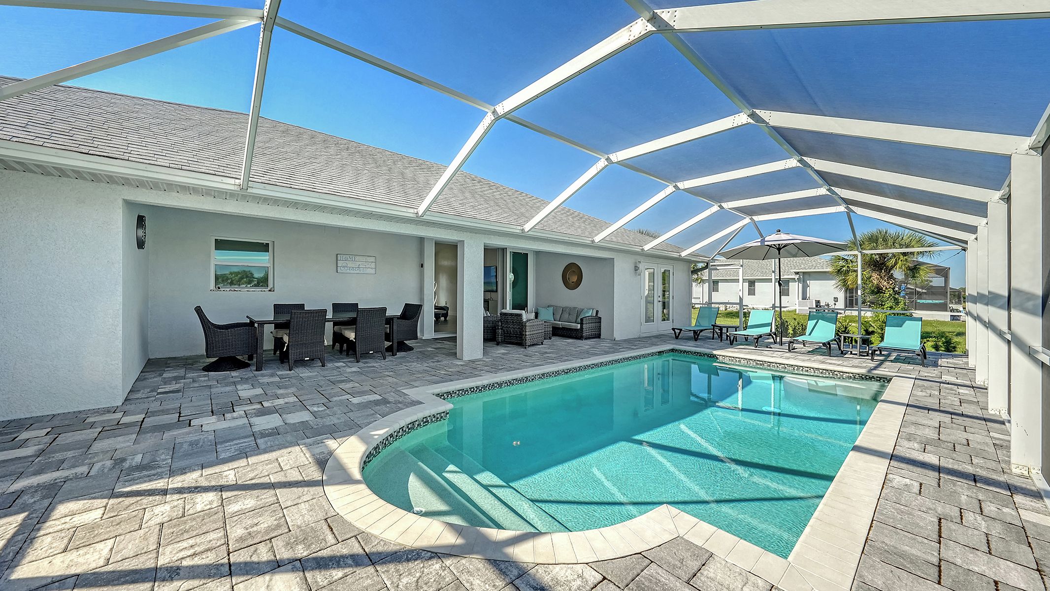 Ein überdachter Außenpool mit Liegestühlen und einer Terrassenfläche.