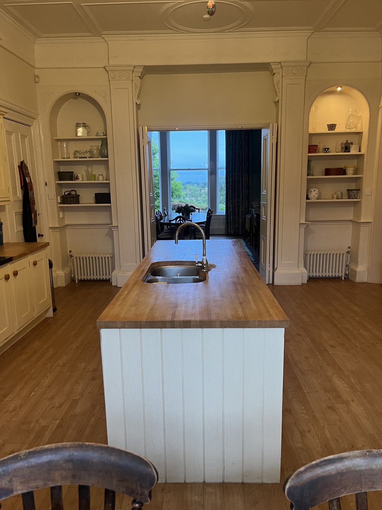 Une cuisine dotée d’un îlot central, de meubles en bois et offrant une vue sur l’extérieur.