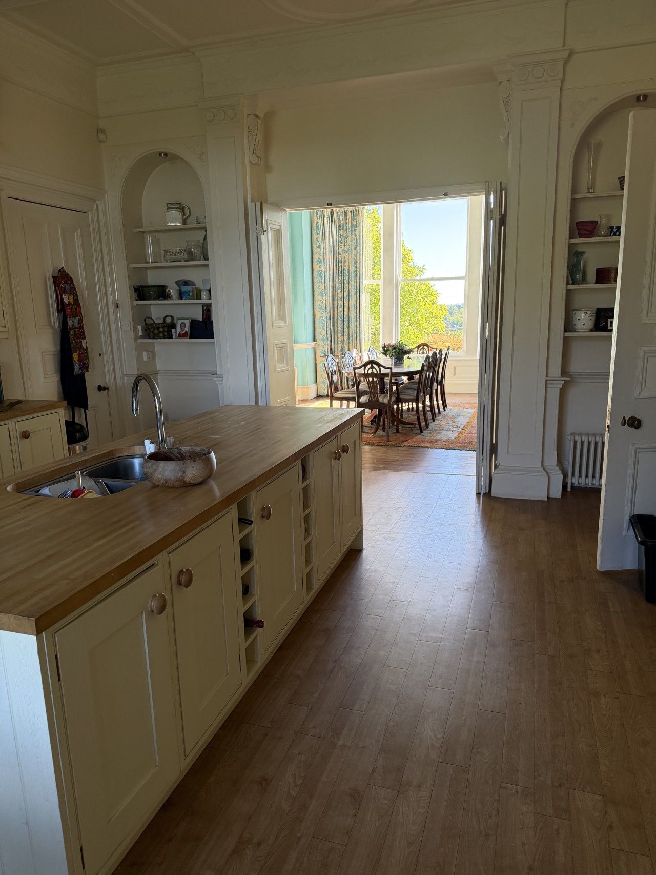 A spacious kitchen with a wooden countertop and a dining area with a table and chairs.