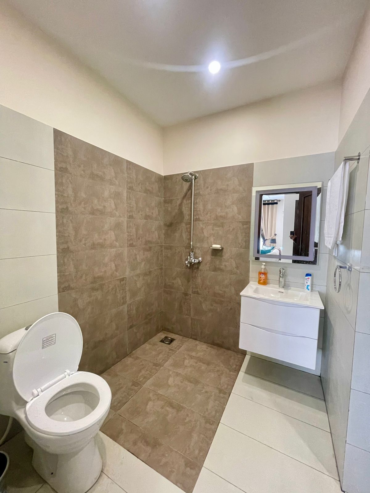 A bathroom with a shower, toilet, and vanity.