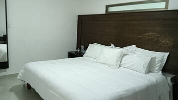 Ein ordentlich bezogenes Bett mit weißen Leinen in einem Hotelzimmer.