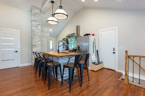 A kitchen with a central island, bar stools, a stove, and a refrigerator. - Riverfront oasis. Scandinavian sauna. Great fishing. (lyndon)