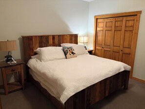Une chambre à coucher avec un lit en bois, une table de chevet avec une lampe et une armoire.