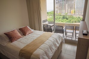 Una habitación de hotel con cama, escritorio y vista a la ciudad.