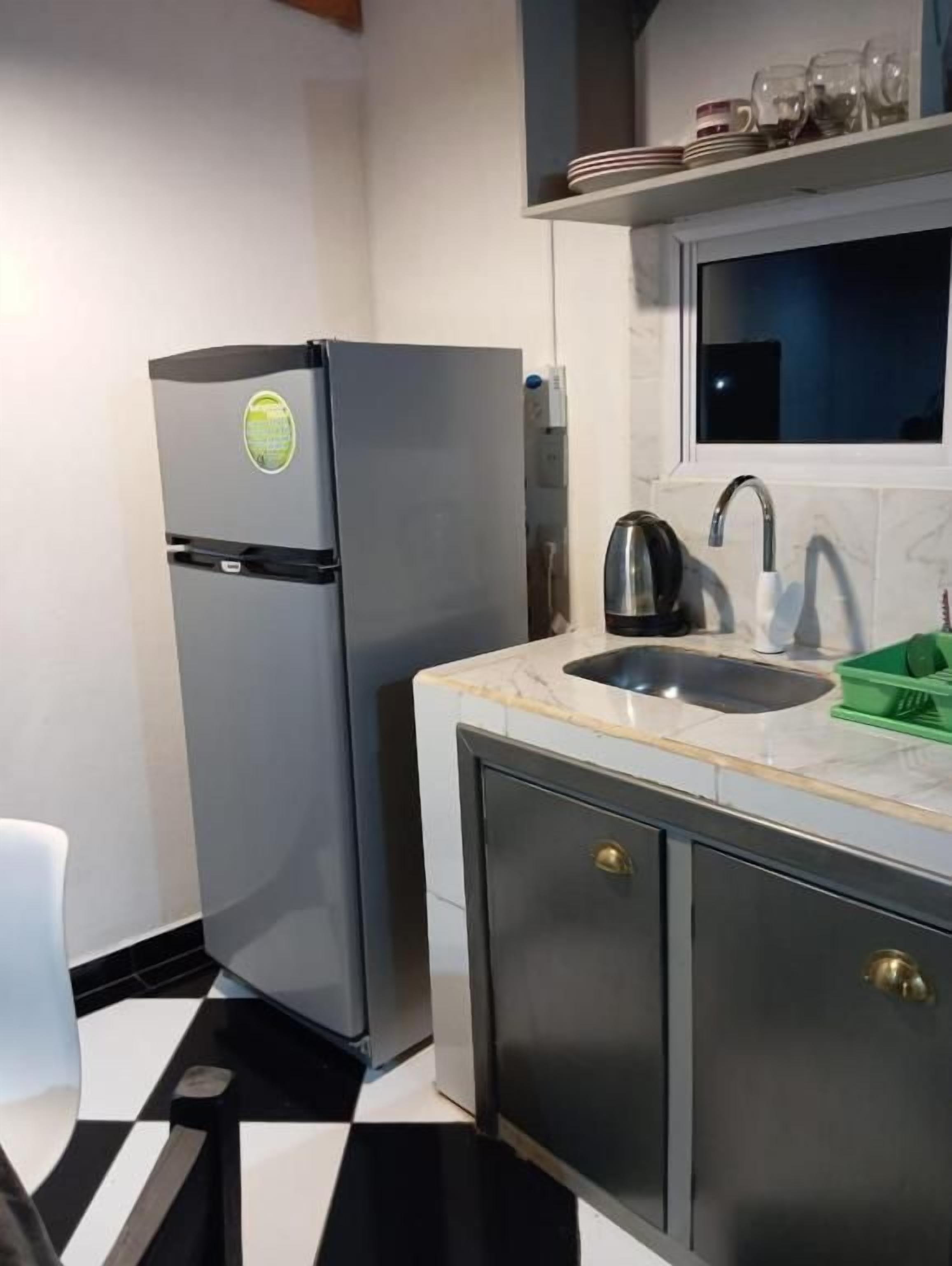 A compact kitchen with a refrigerator, a sink, and a countertop.