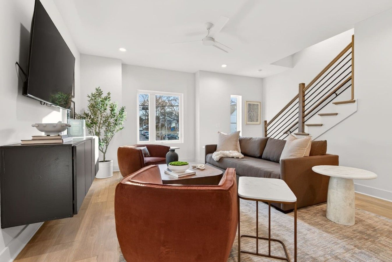 A modern living room with a sofa, coffee table, and a TV mounted on the wall.