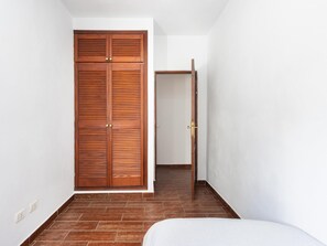 A room with a wooden wardrobe, a door, and a bed. - CHL La Plaza, amazing views Tenerife (Santa Úrsula)