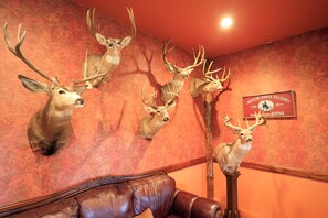 Ein Zimmer mit an der Wand befestigten Hirschköpfen und einem Schild mit der Aufschrift 'Bucking Horse Saloon'.