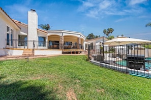 Ein Wohnhaus mit Schwimmbad, überdachter Terrasse und gepflegtem Rasen.