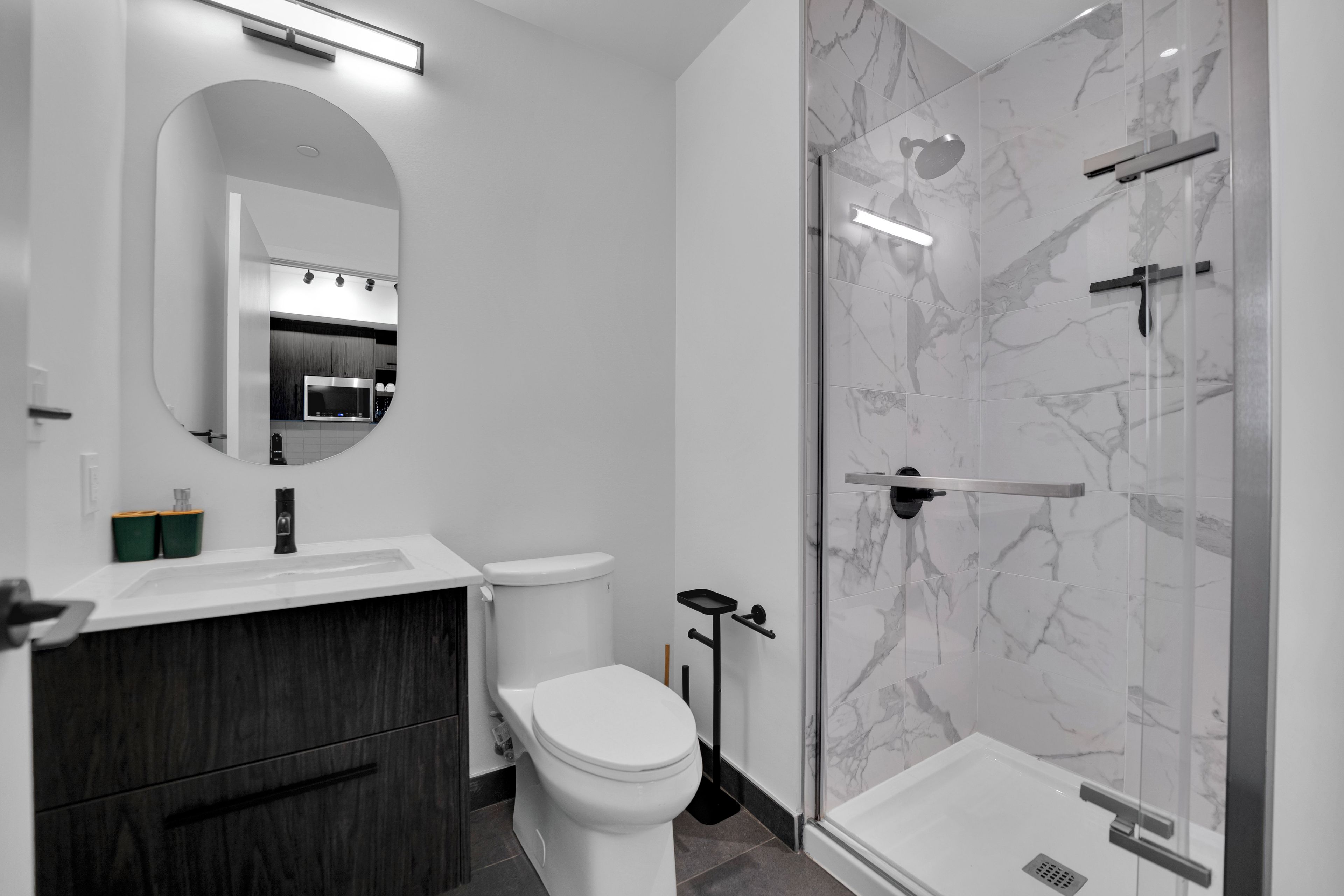 A modern bathroom with a toilet, sink, and shower.