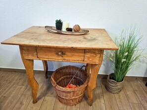 A wooden table with a drawer, a wicker basket underneath, and a potted plant beside it. - Bergzeit-Stoder by Interhome (Hinterstoder)