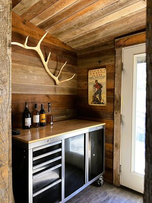 Ein Holzinterieur mit einer Bar, Flaschen und einem Plakat.