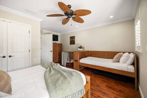 A bedroom with a bed, a wooden bench, a ceiling fan, and a wardrobe. - 6-Acre Lakeside Retreat | Kayaks, Jacuzzi & Stunning Sunrises (Sebring)