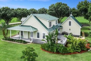 A two-story house with a covered porch and a fenced yard.
