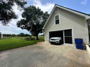 A single-story house with a garage, a driveway, and a tree in the background.