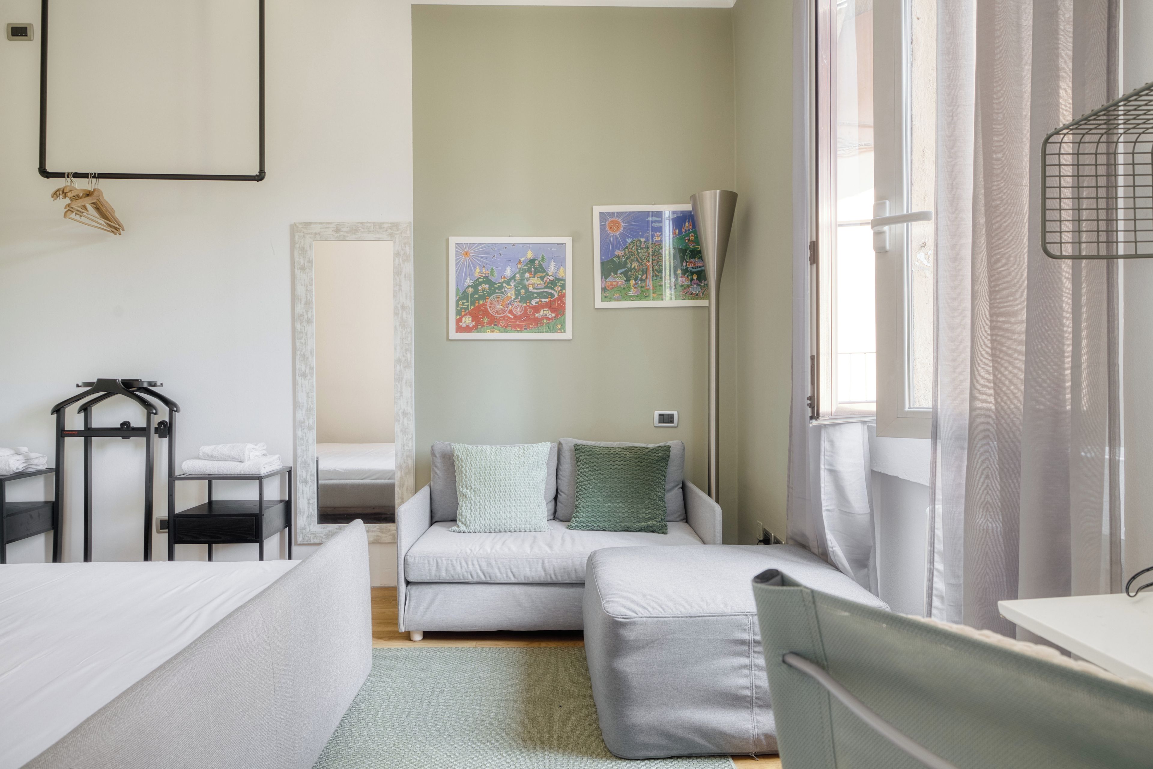 Une chambre à coucher comprenant un lit, une table de chevet, une chaise, une armoire et une fenêtre avec des rideaux.