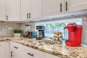 A kitchen with white cabinets, a coffee maker, a toaster, and a coffee grinder. - Vibrant, Spacious Austin Getaway, 4BR, Sleeps 10, Near Downtown & Mueller (Austin)