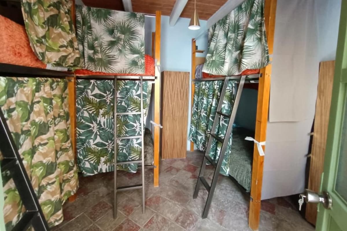 Una habitación con literas, una escalera y una puerta.