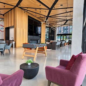 Ein modernes Interieur mit einem Kicker, einer Sitzecke und einem großen Fenster mit Blick nach draußen.