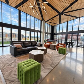 A spacious interior with a high ceiling, large windows, and a modern seating arrangement. - Downtown SLC Studio | King Bed + Free Parking (Salt Lake City)