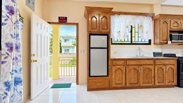 A kitchen with wooden cabinets, a refrigerator, and a microwave.