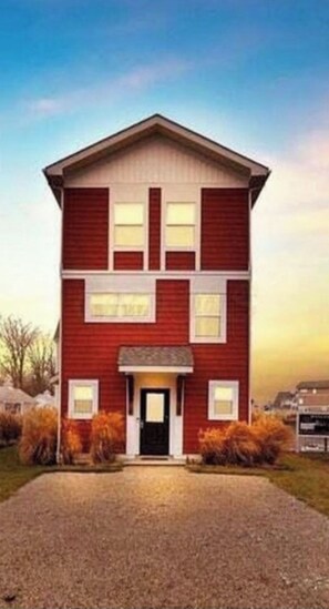 A two-story building with a symmetrical facade, a central entrance, and a driveway leading to the front. - Charming 3-bedroom house on Buckeye Lake right next door to winery! (Thornville)