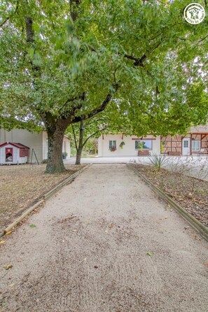 A paved pathway leading to a building with a red-roofed structure on the left. - La Chardenière - MONTJAY (MONTJAY)