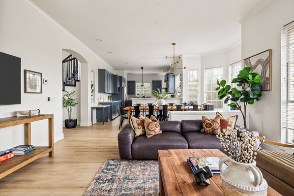A modern living room with a dark leather sofa, wooden coffee table, and a patterned rug.
