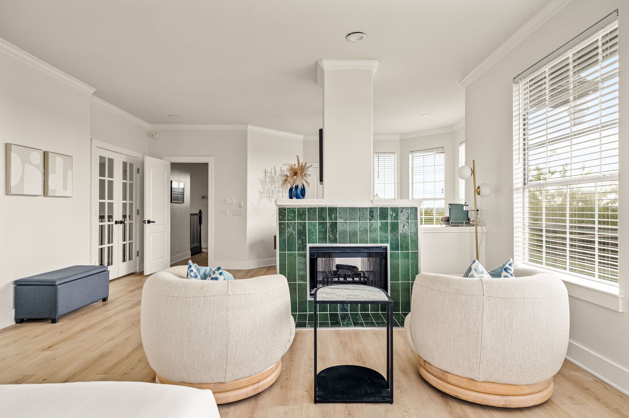 A modern living room with two round seating areas, a fireplace, and large windows.