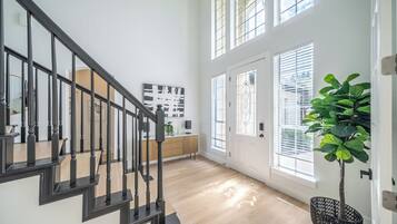 A staircase with black railings, a wooden floor, and a door with a glass panel.