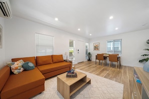 A modern living room with a sofa, coffee table, and dining area. - Charming Atwater Village Retreat 2BR + 2BA (Los Angeles)