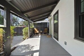 A covered patio area with a wooden ceiling, a welcome mat, and two wooden chairs. - Charming Atwater Village Retreat 2BR + 2BA (Los Angeles)
