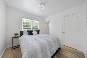 A bedroom with a bed, bedside table, and a window. - Charming Atwater Village Retreat 2BR + 2BA (Los Angeles)