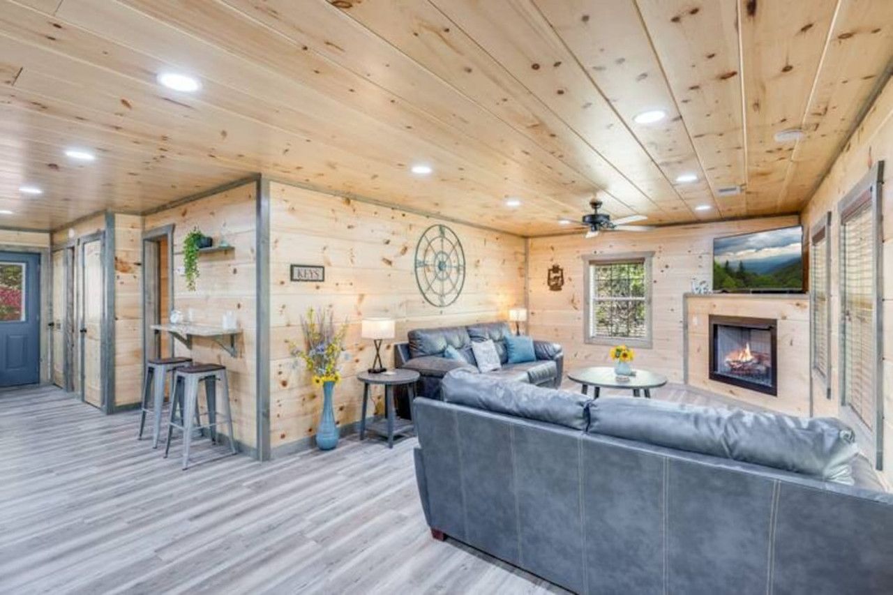 A wooden interior with a sofa, a small table, and a fireplace.