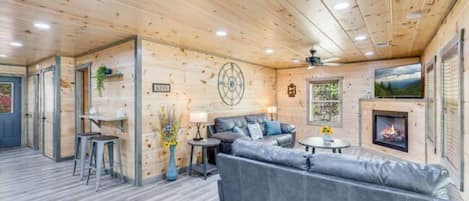 Un interior de madera con un sofá, una pequeña mesa y una chimenea.