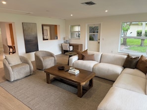 A living room with a sofa, armchairs, a coffee table, and a rug. - Beach, Golf, & Fitness Getaway, Newly Renovated. (Naples)