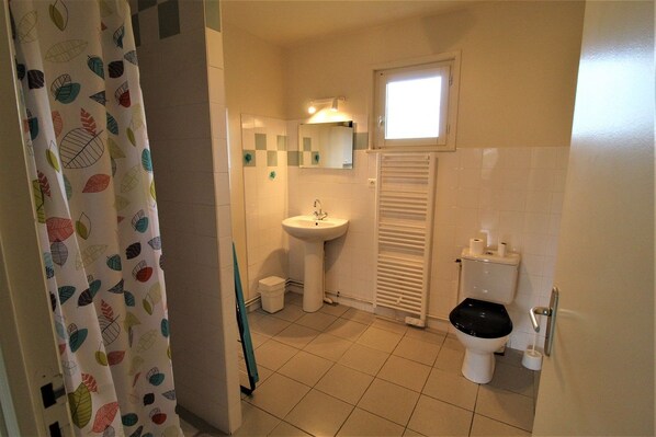 Un baño con lavamanos, inodoro y ventana.